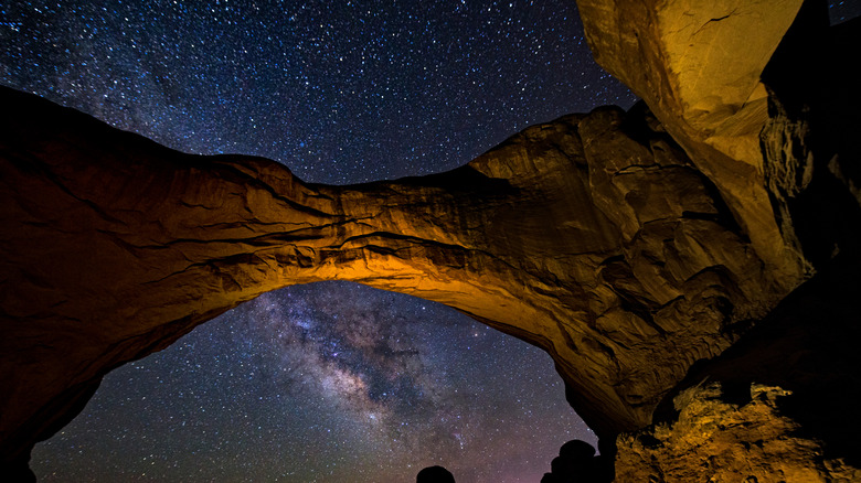 milky way with arch stone formation in foreground