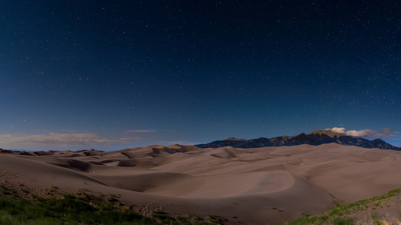 starry sky above waves of dunes stretching out in the distance