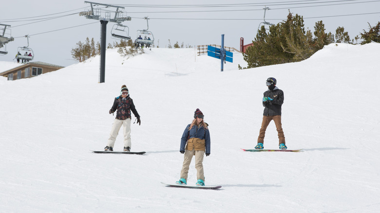 Three snowboarders on the slopes at Mammoth Mountain in Mammoth Lakes, California