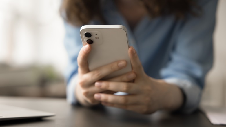 Close-up view of a woman's hands holding a smartphone