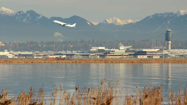 Plane taking off from airport among mountains