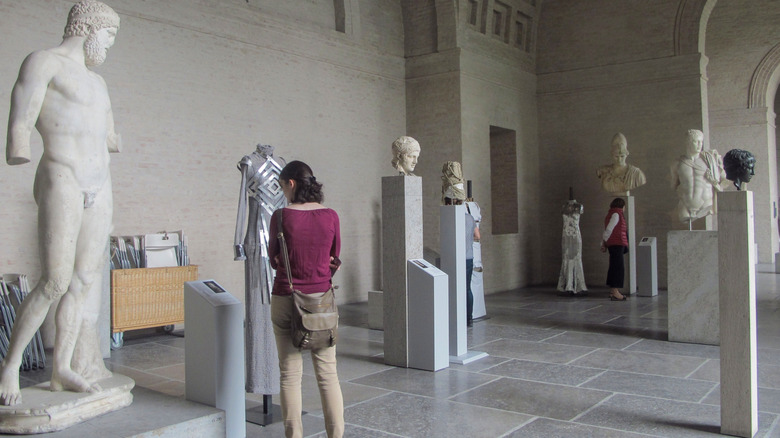 Visitors look at ancient statues on display at the Glyptothek museum, Munich.