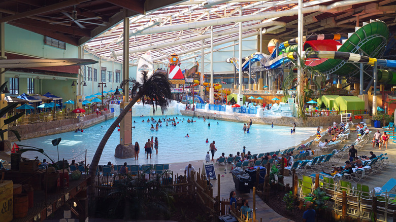 View of Aquatopia Indoor Waterpark featuring a pool, multiple playsets, and families having fun at the Camelback Resort in Pennsylvania's Pocono Mountains