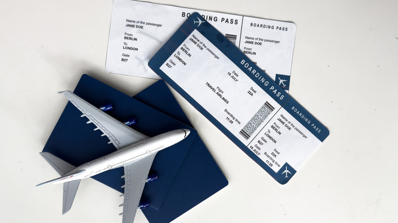 Toy plane sitting on passports next to boarding passes