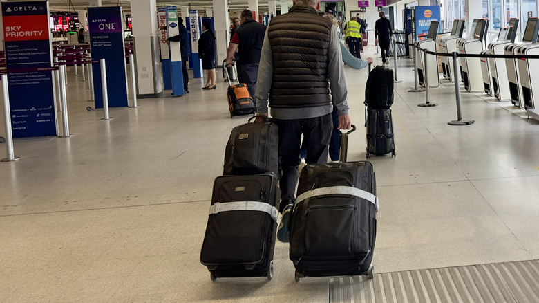 Person walking with multiple suitcases.