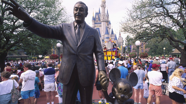 A statue of Walt Disney and Mickey Mouse stands in front of Cinderella's Castle at Magic Kingdom in Orlando.
