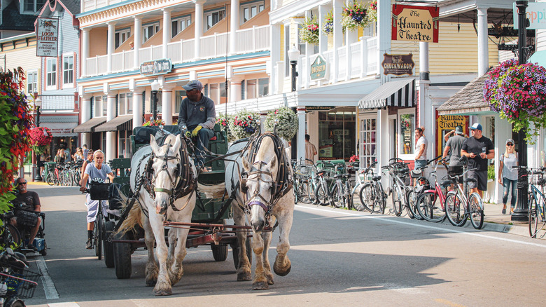 A horse-drawn carriage rolls down Main Street, Mackinac Island, Michigan
