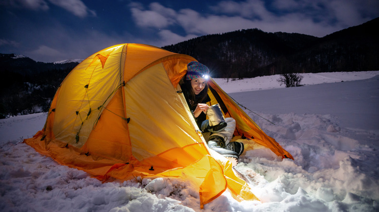 A camper in a tent in the snow