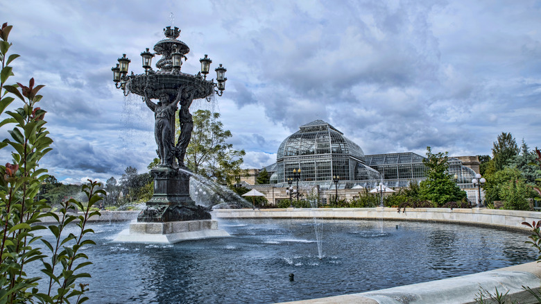 A fountain at the United States Botanic Garden with a glass conservatory in the background