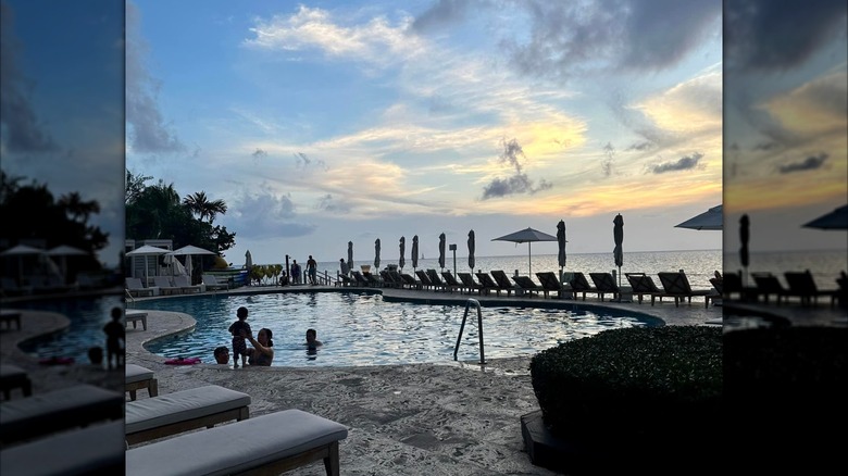 Guests playing in the pool at sunset at the Grand Cayman Marriott Resort