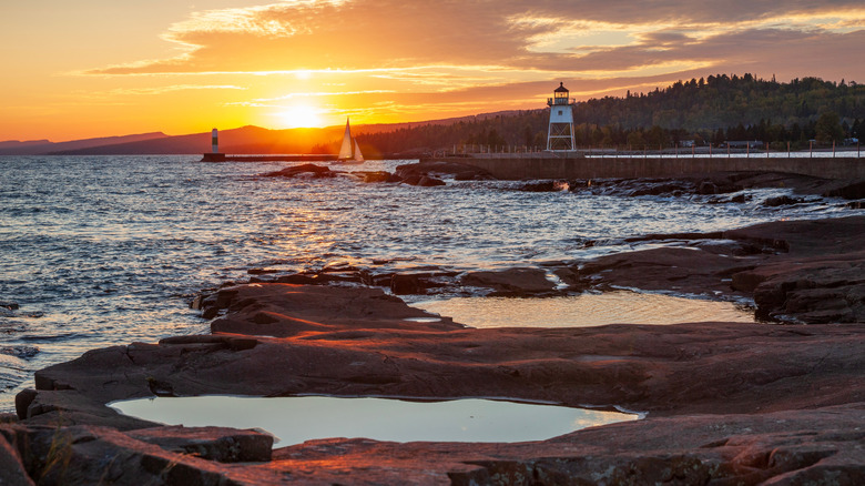 A sailboat enters the harbor at Grand Marais, viewed from Artist's Point at sunset in autumn
