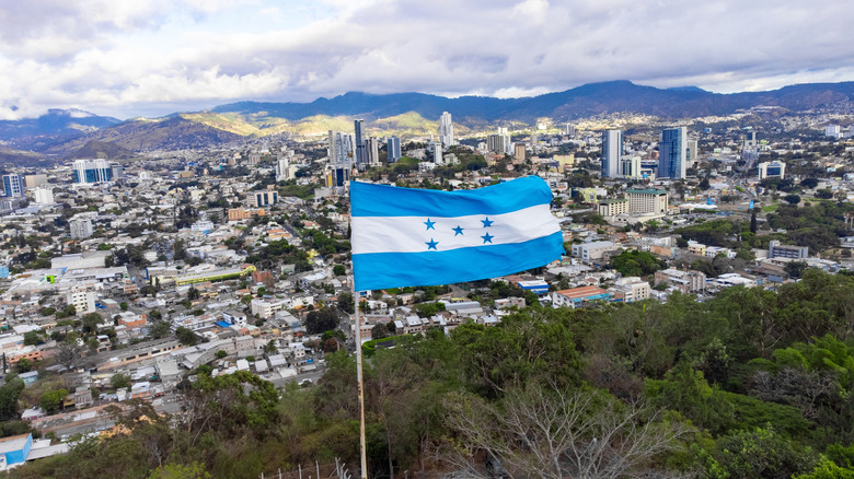 Honduras flag raised on Tegucigalpa, the Capital City of Honduras with the city below in the background