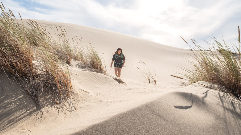 A woman hiking on the sand at Oregon Dunes National Recreation Area
