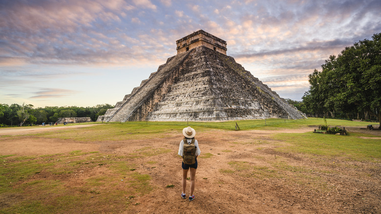 A tourist gazes up at a Mayan pyramid in Mexico