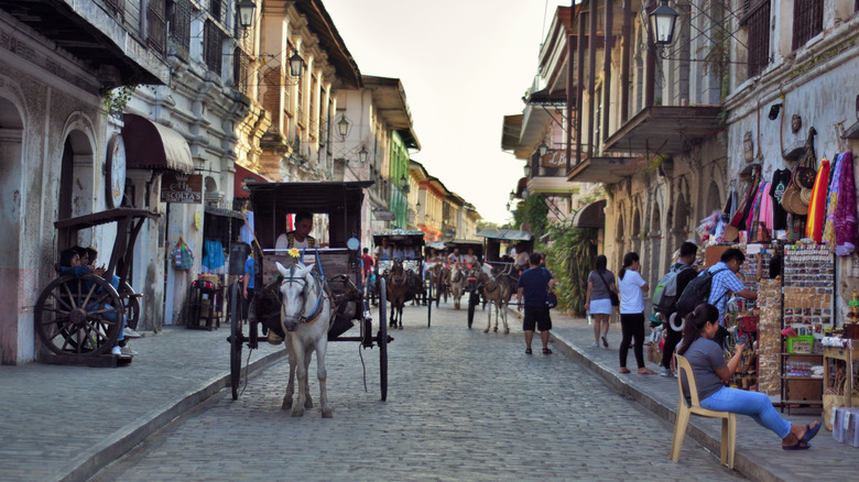 A horse-drawn carriage heads down a street in Vigan