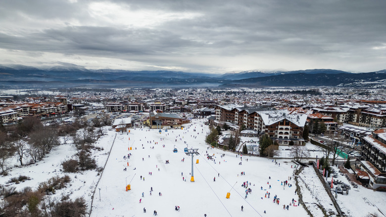 Aerial view of busy ski resort with dark storm clouds in the sky.