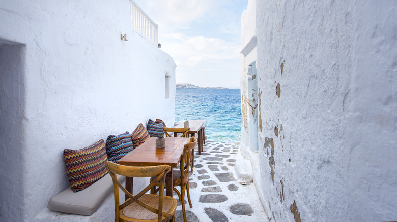 Chairs and tables in a traditional Greek taverna restaurant near the water in Mykonos, Greece