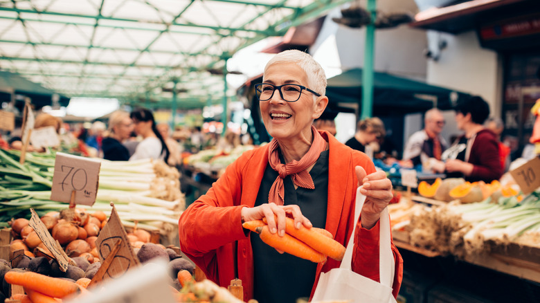 Woman smiling while food shopping in market