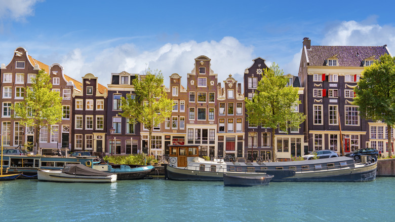 Traditional gabled houses along Singel canal in Amsterdam on a sunny summer day