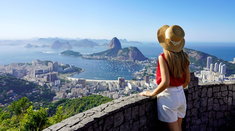 A woman wearing a hat looks over Rio de Janeiro Harbor