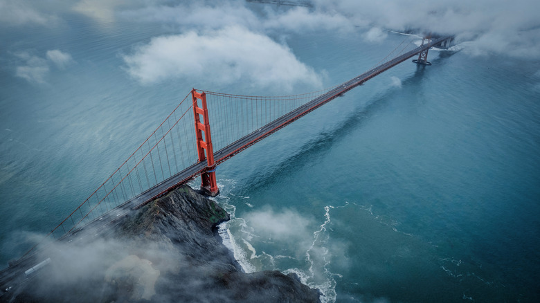 Aerial view of the red Golden Gate Bridge on a stormy, foggy day crossing the bay