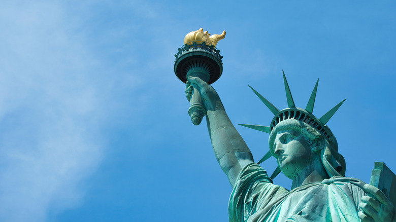Close up of New York's green Statue of Liberty holding her torch high
