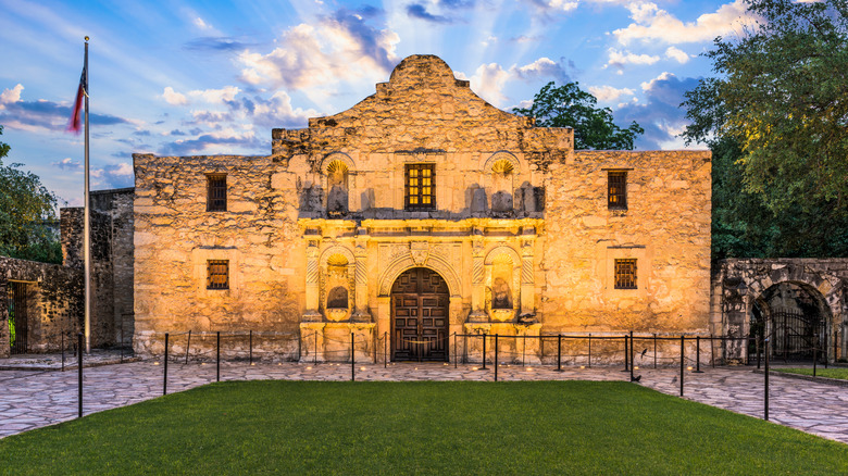 Stone facade of the Alamo in San Antonio, Texas, lit up at dusk