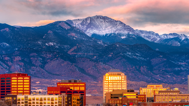 urban Colorado Springs in the foreground at sunrise with Pikes Peak in background