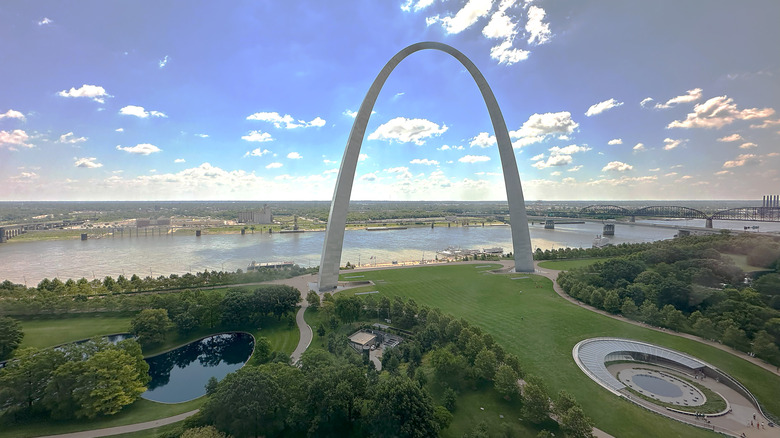 Missouri's white Gateway Arch stands tall above landscaped grounds along the Mississippi River