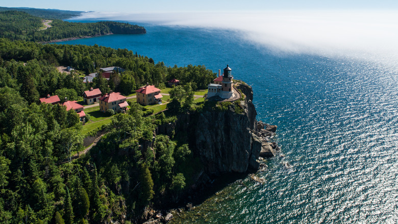 Aerial view of Split Rock Lighthouse atop a cliff overlooking Lake Superior in the summer.