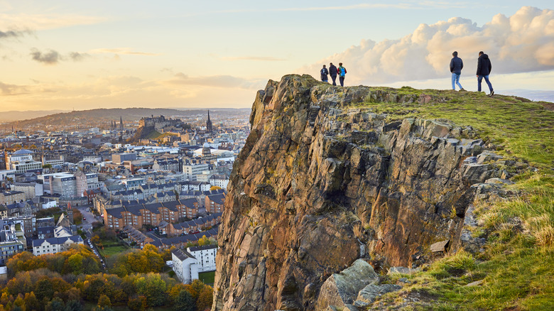 People walking on the top of a cliff overlooking Edinburgh, Scotland
