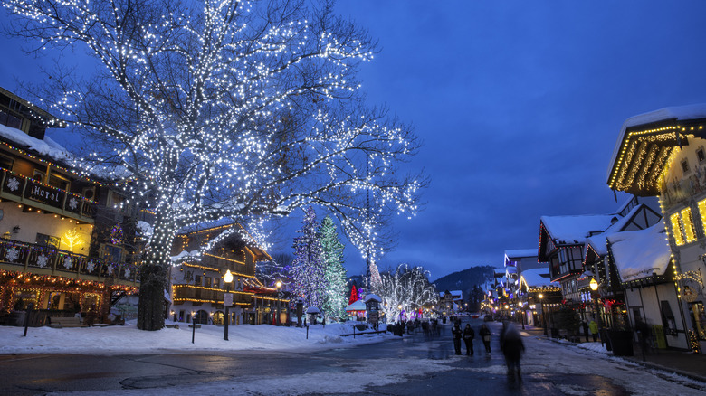 Blue hour in Town of Leavenworth in winter with Christmas lights on Bavarian buildings and trees, Washington, USA