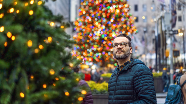 Traveler looking at colorful Christmas tree display