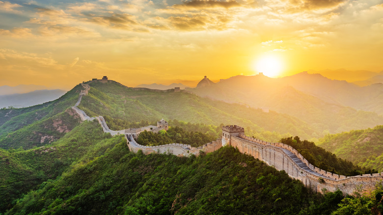 Aerial view of the Great Wall of China traversing through the Chinese mountains at sunset