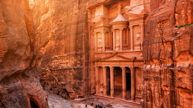 The reddish Petra is carved out of rock in a canyon in Jordan