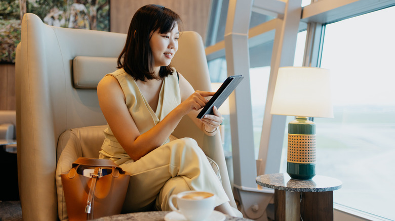 Elegant traveler sitting in a bright airport lounge