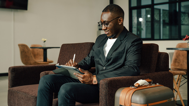 Elegant business traveler using a tablet in an airport lounge