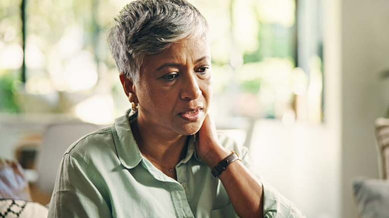 A woman massaging her neck