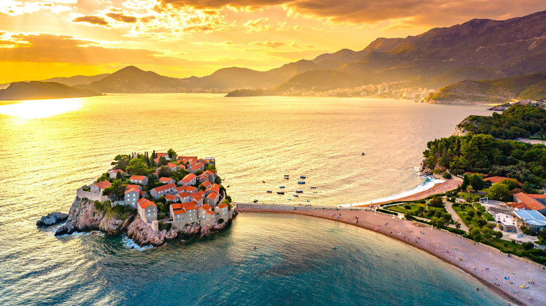 Island of Sveti Stefan connected by a sandbar to Budva, Montenegro, at dusk