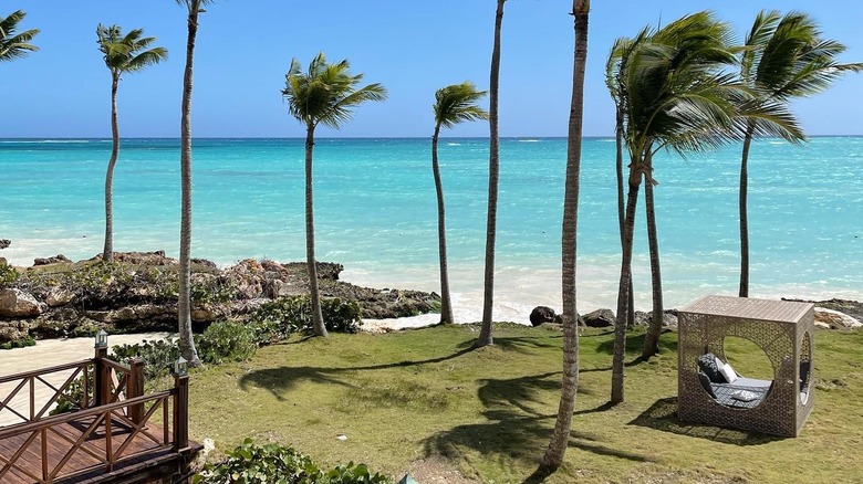 View of ocean, palm trees, and cabana at Sanctuary Cap Cana