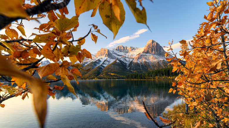 A mountain rises behind a reservoir in Canmore, Albera, in the fall