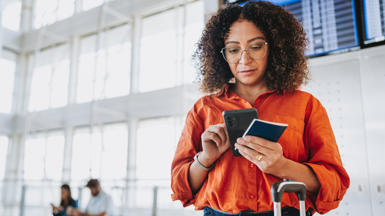 A traveler checking flight information on their phone