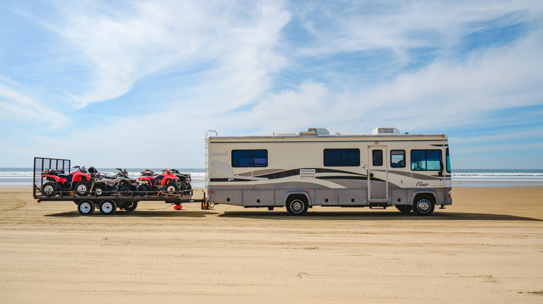 A motorhome towing a trailer of ATVs in Oceano Dunes State Vehicular Recreation Area