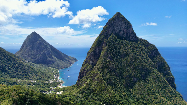 Two towering peaks covered in lush greenery with the ocean stretching before them