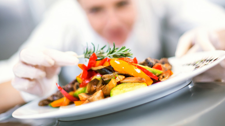 A chef puts this finishing touches on a plate