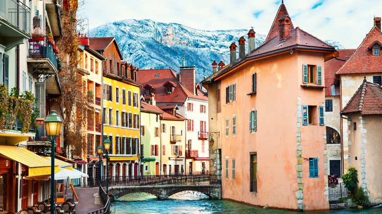 A canal and footbridge is surrounded by colorful buildings in Annecy, France