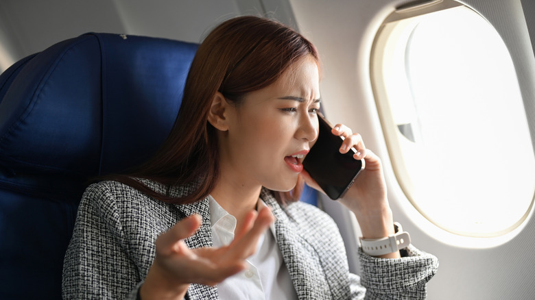 Person talking on a phone during a flight