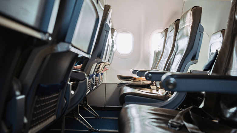 An empty row of seats on a commercial airplane.
