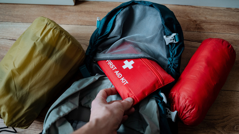 A traveler packing a first aid kit for their hiking trip