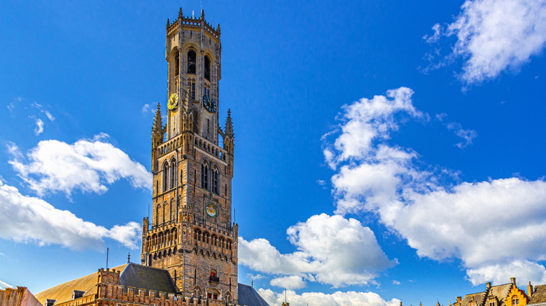 Bruges Belfry tower facade against a blue, cloudy sky